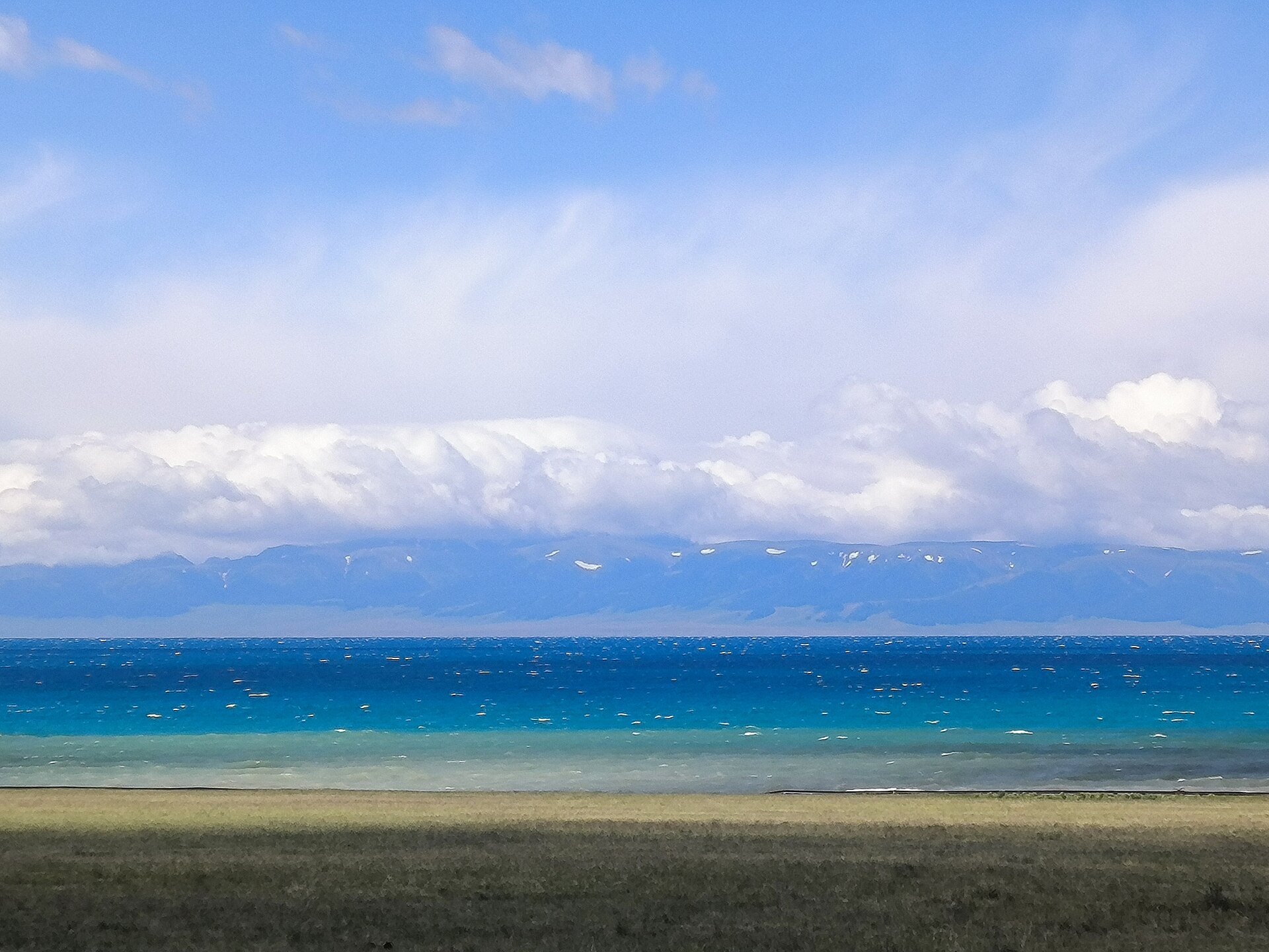 Blue waters and distant mountain scenery at Sayram Lake in Xinjiang